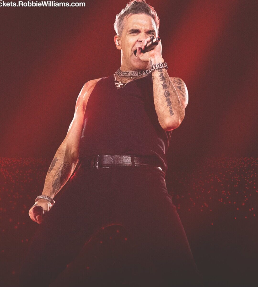 foto del cantante robbie williams mentre si esibisce
